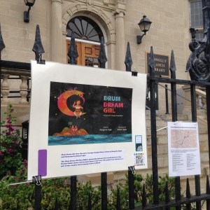 Drum Dream Girl Story Walk page 1 and map located at the library entrance